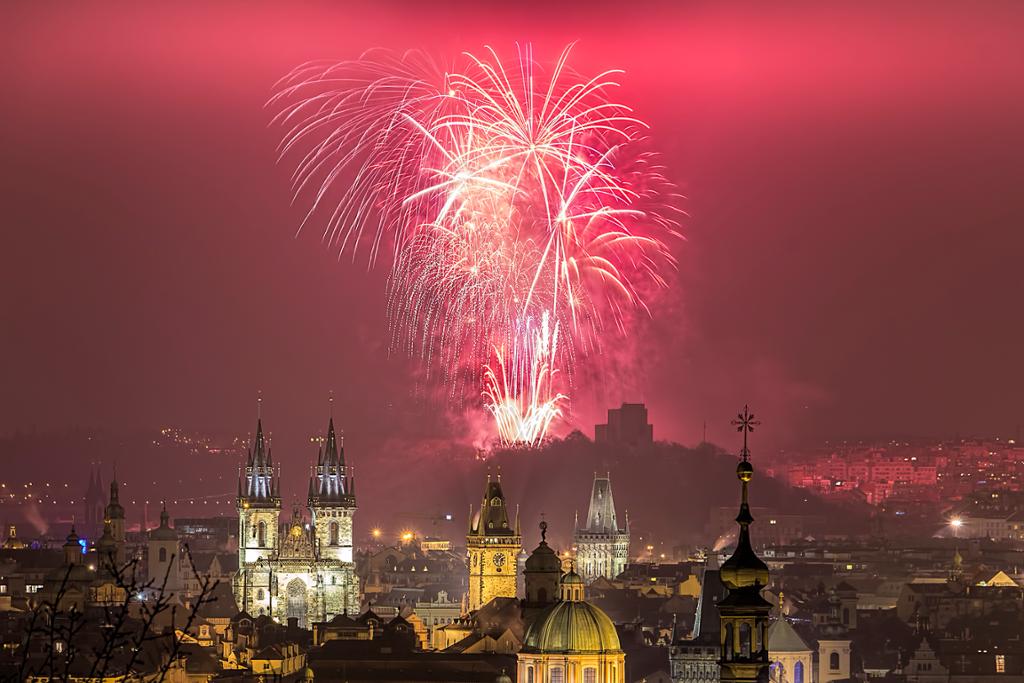 Towers and spires in Prague lit up by fireworks