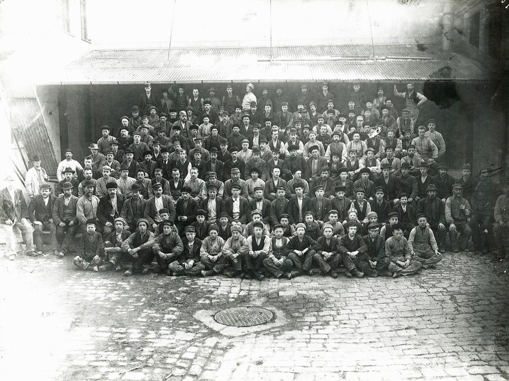 Arbeidsstokken ved Christiania Guldlistefabrik i 1898. Arbeiderne, inkludert barnearbeiderne, er stilt opp til fotografering. Foto. 