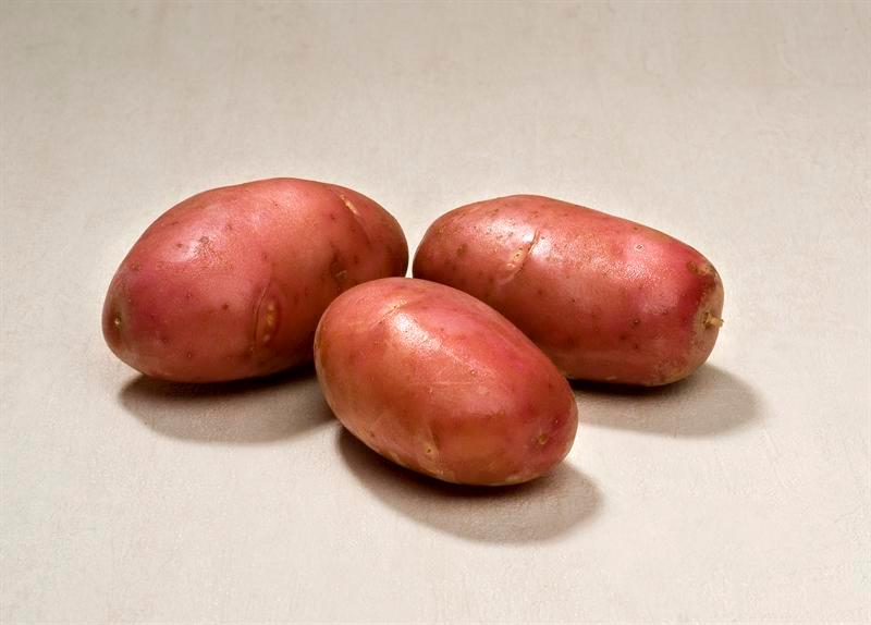 Tre poteter med rødt skall. Foto.