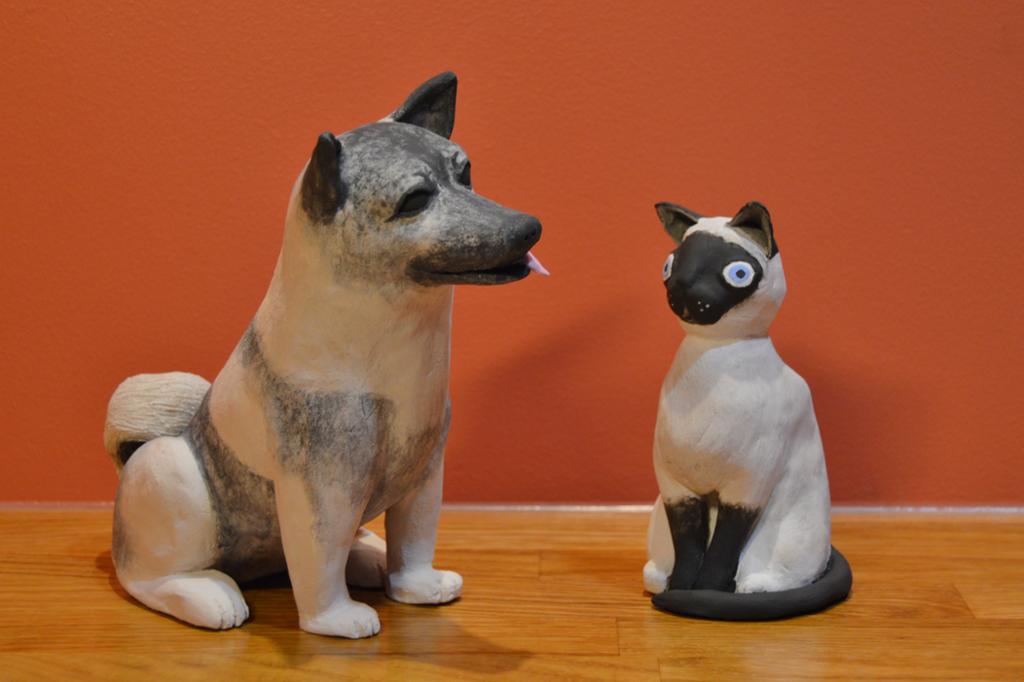 Hunde- og katteskulptur i keramikk. Foto.