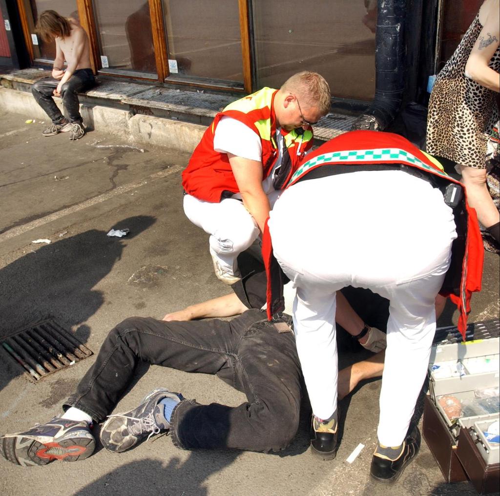 Ambulansepersonell behandler en person som har tatt overdose. Foto.