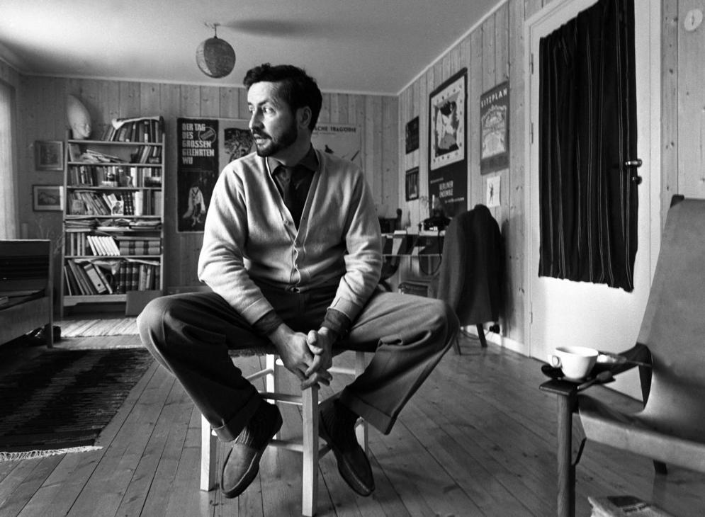 Forfattaren Jens Bjørneboe sit på ein stol i stova si. Svart-kvitt-foto.