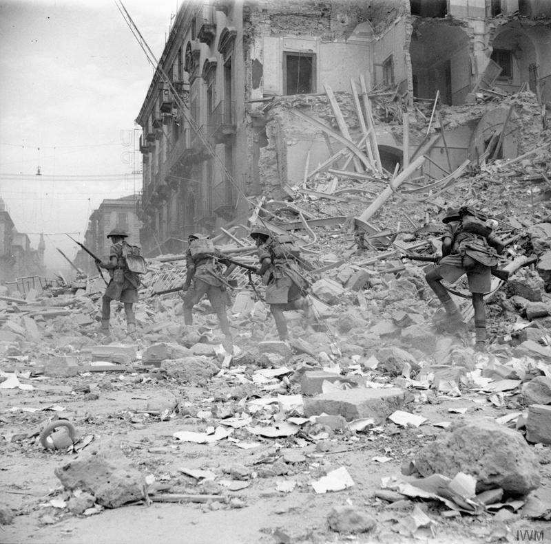 Britisk infanterisoldater går gjennom ruiner i Catania, Sicilia, 1943. Foto.
