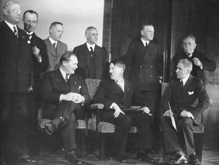 Pressemøte etter det første møte i Hitlers nye regjering, 30. januar 1933. Hitler sittende i stol med kabinettmedlemmer rundt seg. Foto.