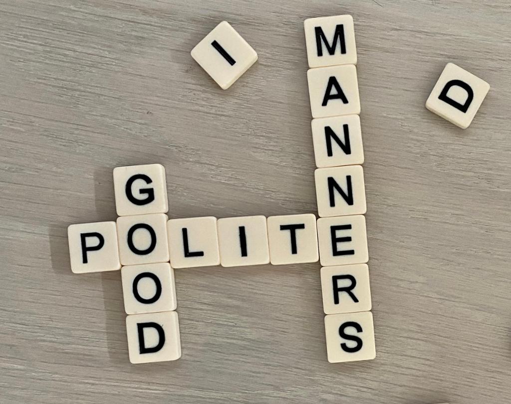 Letter tiles spelling out the words polite, good, and manners. 