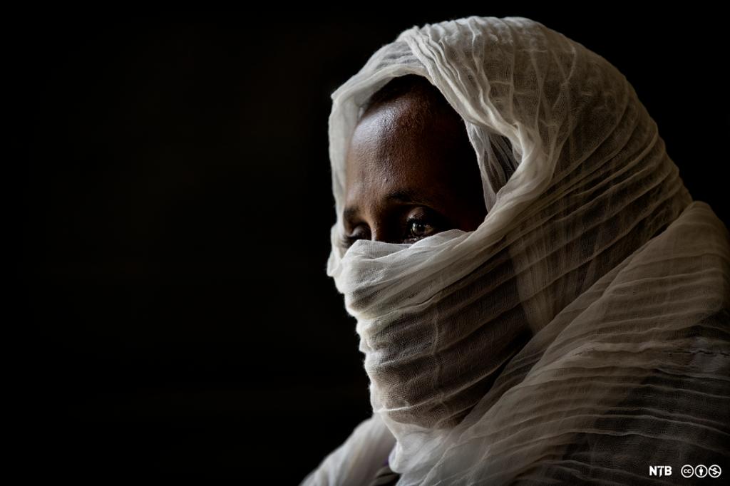 Ansiktet til ei etiopisk kvinne som er dekt til av eit kvitt sjal, berre panna og auga er synlege. Foto.