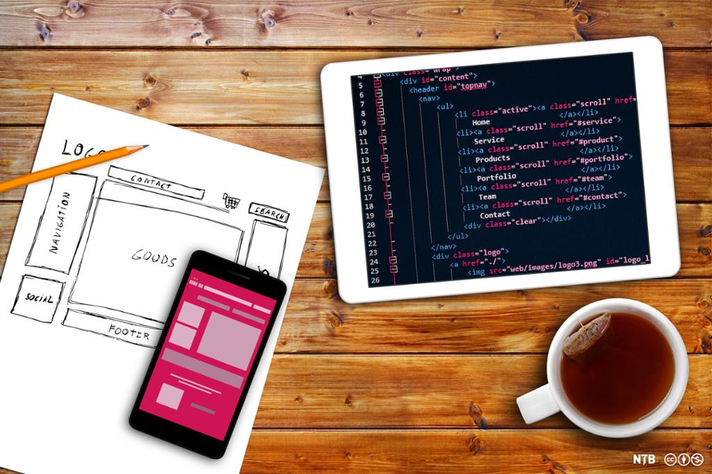 Nettbrett med kode, et skisseark med enkelt oppsett av en nettside, en digital skisse med røde og rosa firkanter som viser oppsett av en nettside og en tekopp. Foto. 