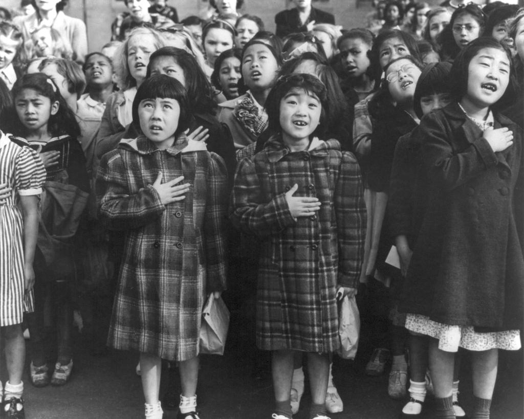 Barn av forskjellige opprinnelse, inkludert evakuerte japanske barn, framsier troskapseden til det amerikanske flagget, San Francisco 1952. Foto.
