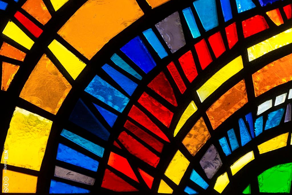 Nærbilde av glassmaleri med klare farger i en kirke. Foto.