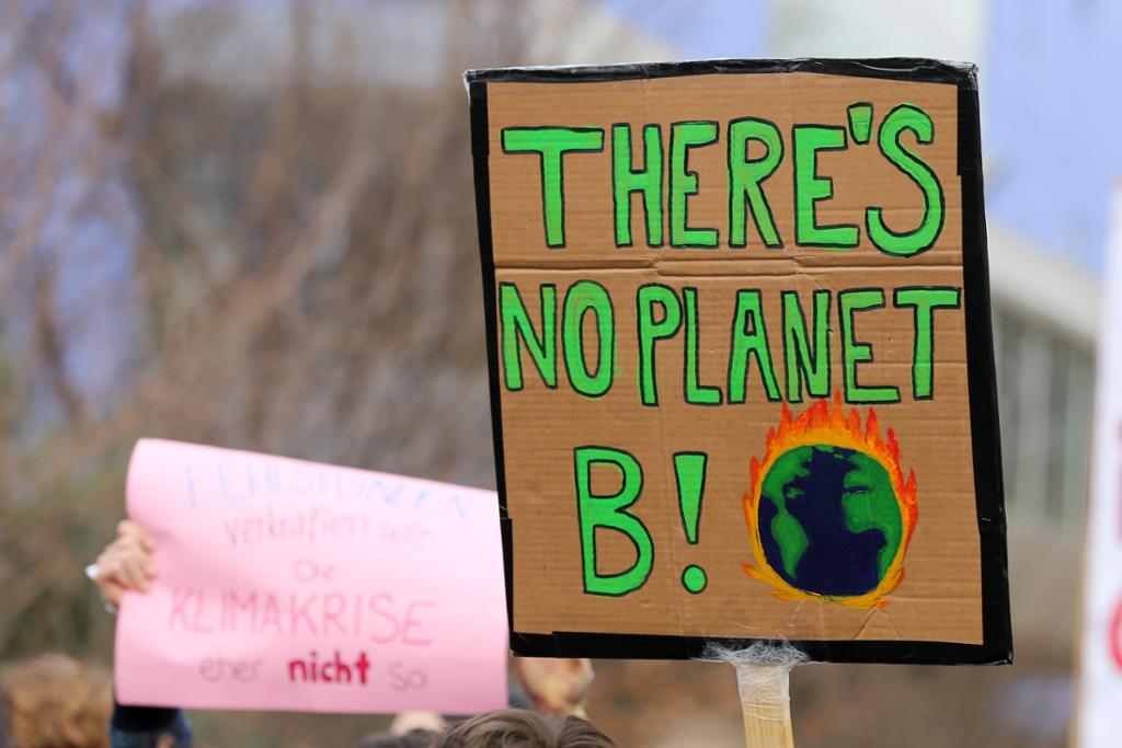 Ein plakat med ein brennande jordklode og teksten "There's no planet b!". Foto. 