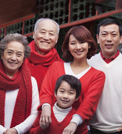 En storfamilie kledd i rødt og hvitt poserer smilende for kameraet. Foto.