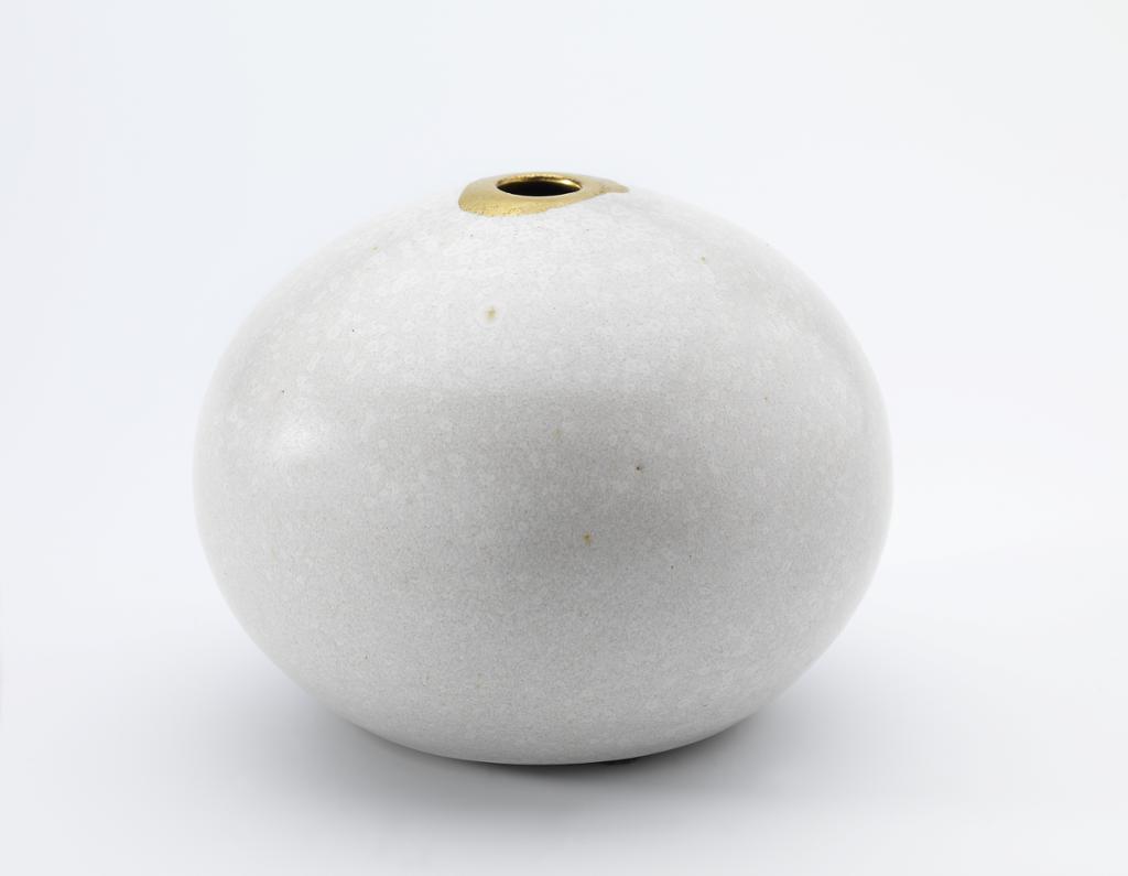 Hvit, rund keramikkvase. Foto.