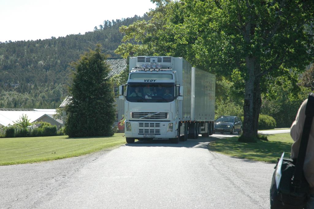 En trailer som frakter matvarer kommer kjørende på en landlig vei. Foto.