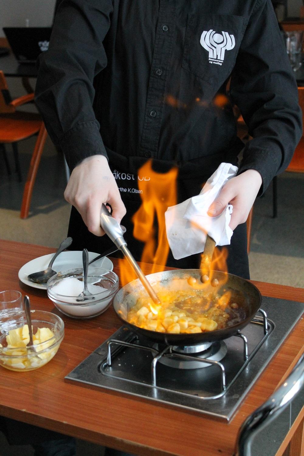 Bananer i biter flamberes i en stekepanne. Foto.