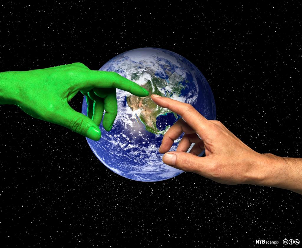 En grønn hånd og en menneskehånd rører ved hverandre. Jordkloden i bakgrunnen. Foto.