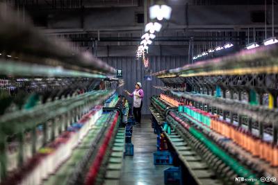 En kvinne arbeider i en moderne fabrikk for silkeproduksjon i Shengze i Kina. Foto. 