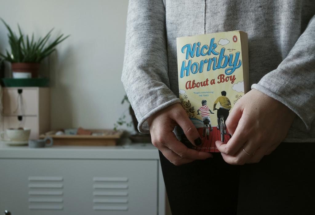 Person holder boka About a boy av Nick Hornby. Bilde.