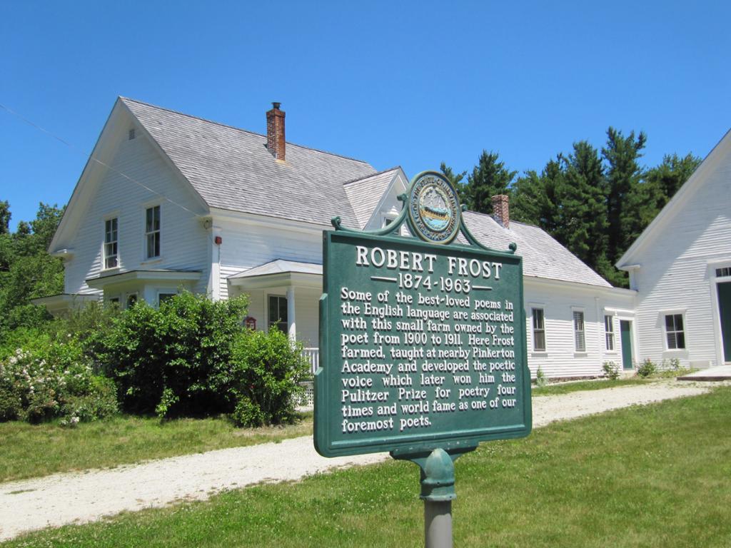 Picture of sign on a lawn outside a white house. The sign says that Robert Frost owned this farm in New Hampshire from 1900 to 1911. 