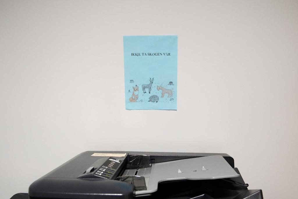 En printer med en tegning på veggen over. På tegningen er det ulike dyr og teksten "ikkje ta skogen vår". Foto. 