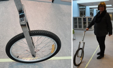 Sykkelhjul montert på en enkel ramme med håndtak slik at hjulet enkelt kan trilles bortover. Foto.