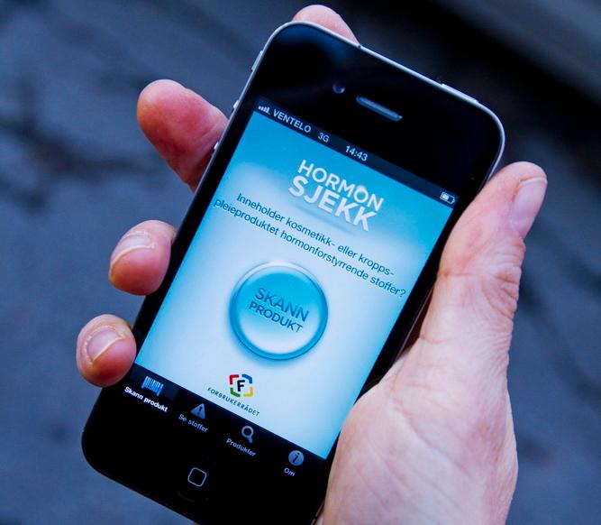 En hånd holder en mobil som viser en app der man kan sjekke hormoninnhold. Foto. 