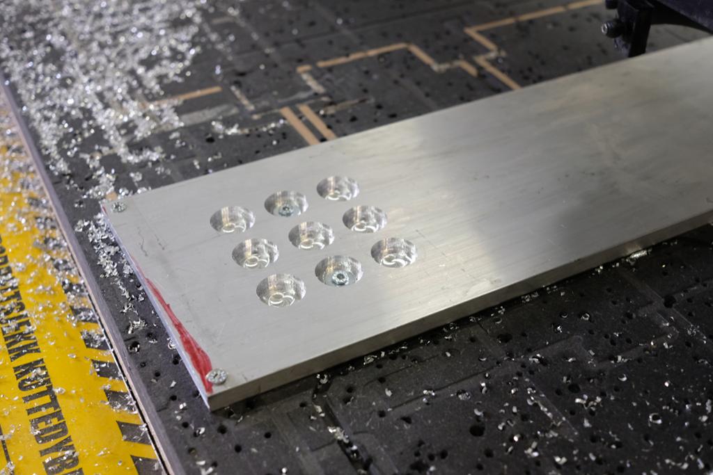 Spelebrett til tre-på-rad-spel laga av aluminium. Foto.