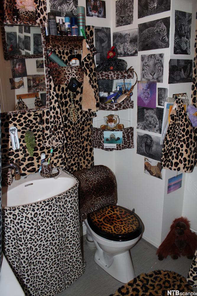 Toalett med masse gjenstander og pynt i leopardmønster. Foto.