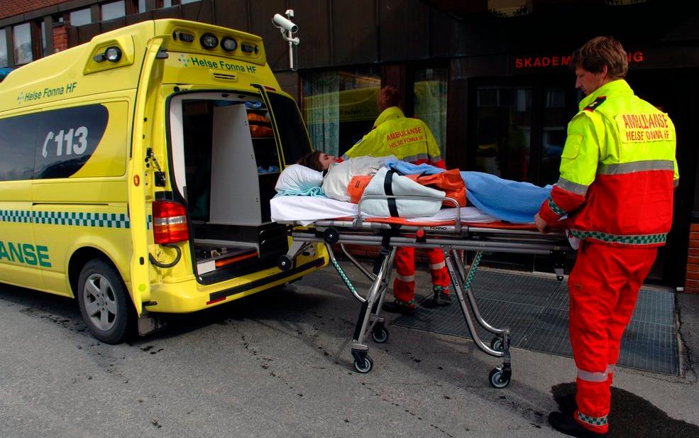 Pasient på båre som trilles inn i en ambulanse