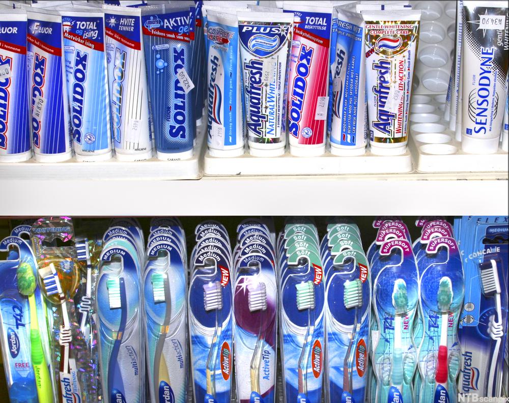 Tannkrem og tannbørster i en butikkhylle. Foto.