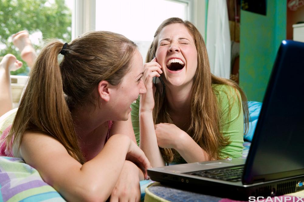 Jenter ler ved datamaskin. Foto.