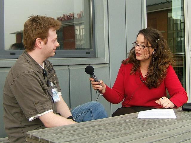 En person intervjuer en annen med mikrofon. Foto.