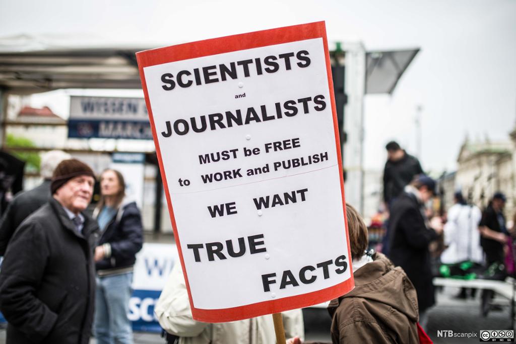 Plakat i demonstrasjonstog som krever sanne fakta i journalistikk og vitenskap. Foto.