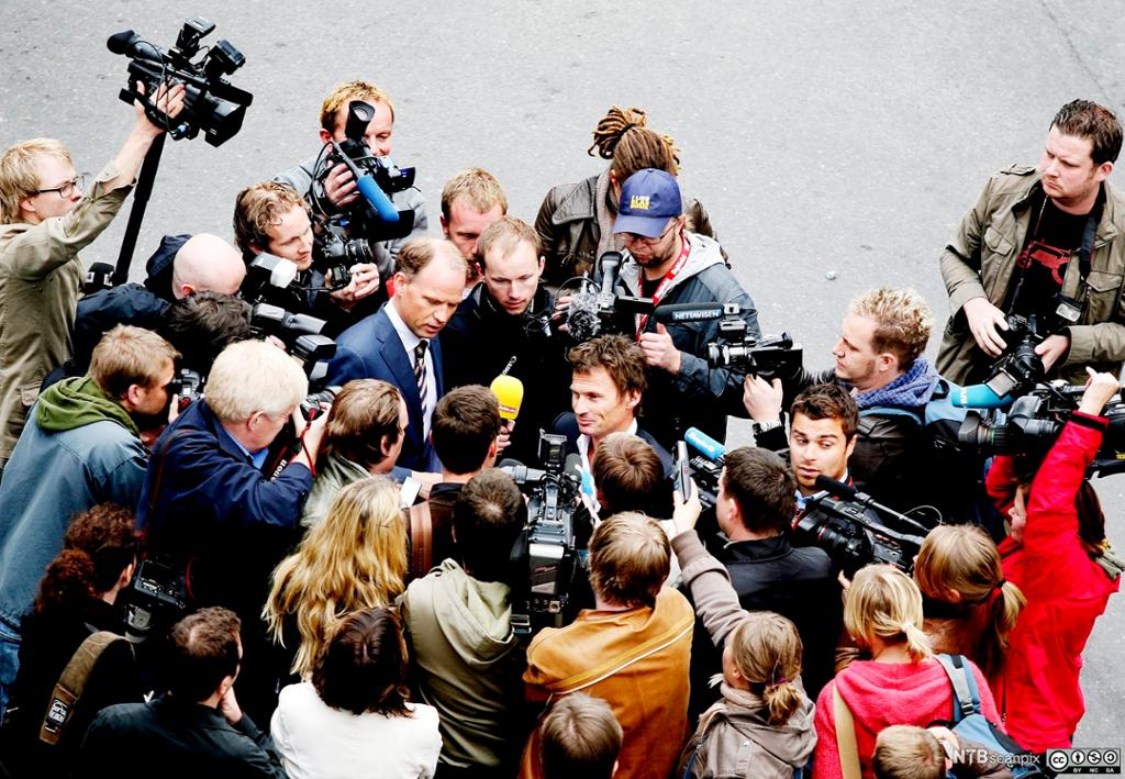 Petter Stordalen omringet av journalister og fotografer. Foto.
