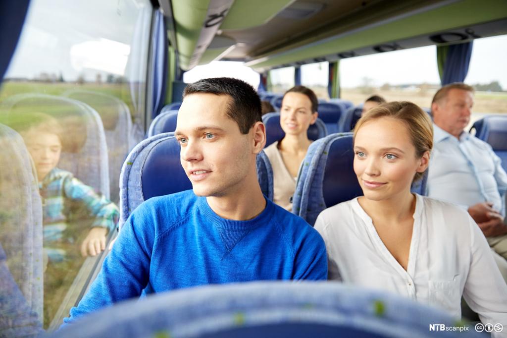 Et ungt par som sitter i en buss. Foto.
