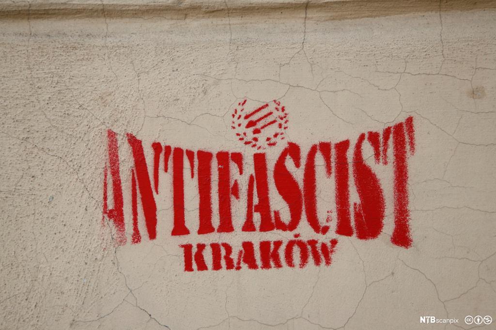 Rød grafitti på murvegg som sier "Antifascist Krakow". Foto. 