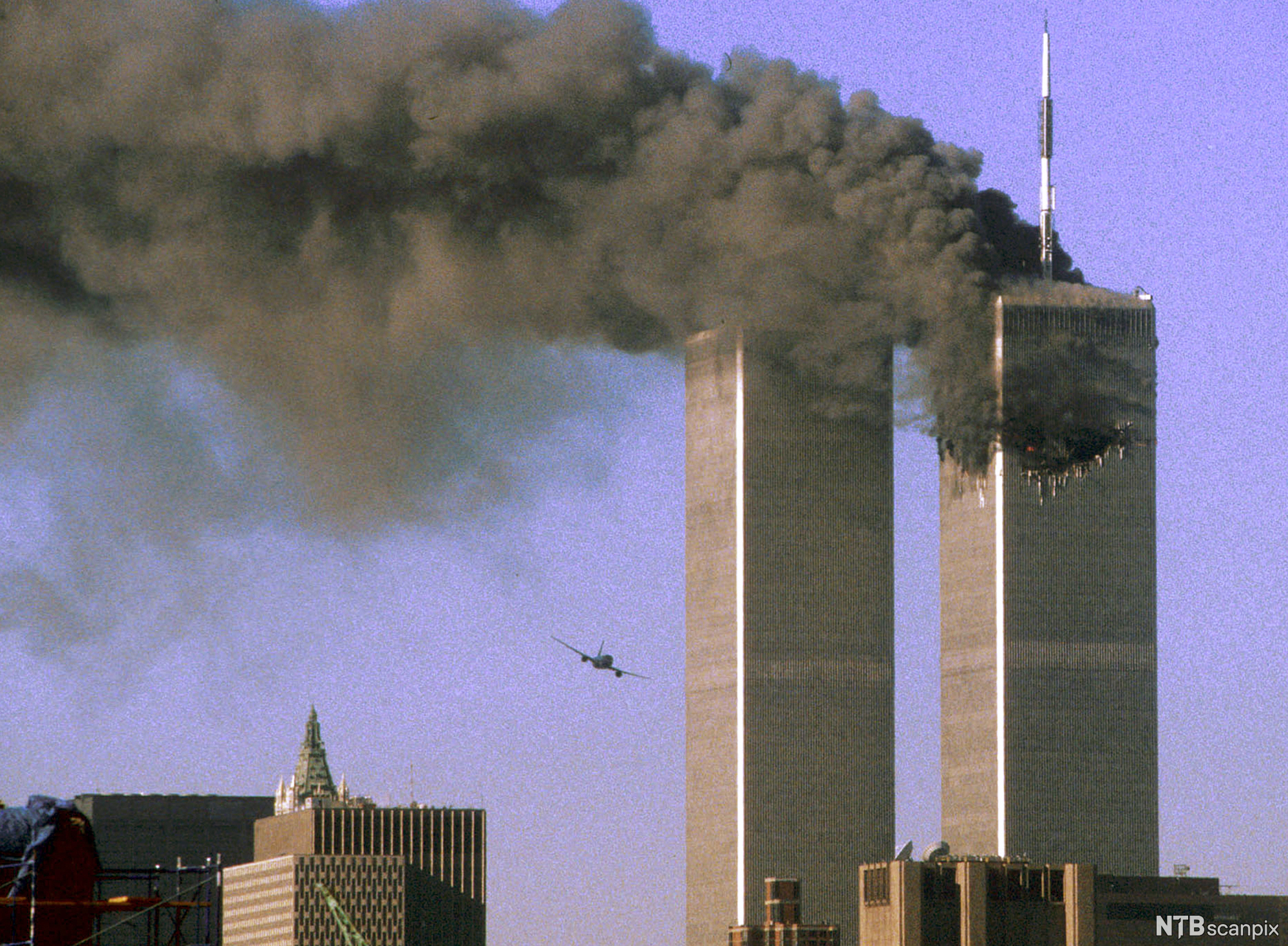Eit fly er på veg til å krasje inn i World Trade Center. Foto.
