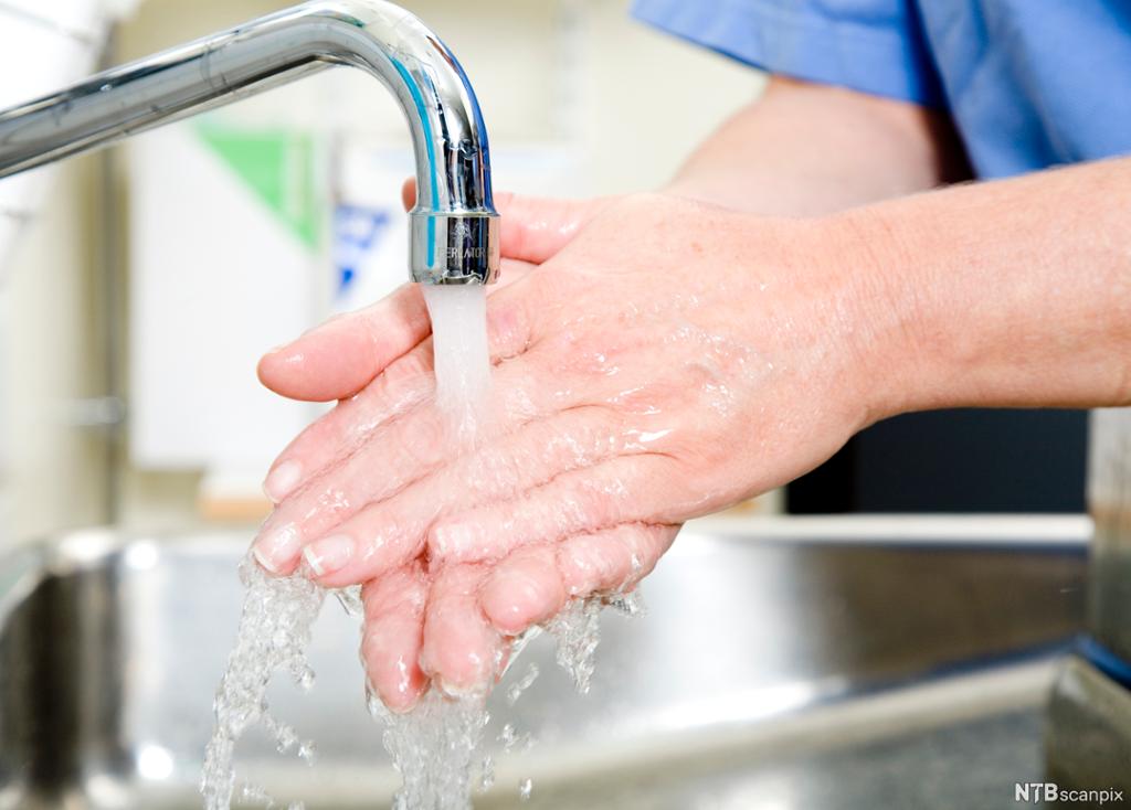 Helsefagarbeider vasker hendene. Foto.