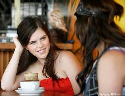 To unge kvinner drikker kaffe sammen på kafé. Foto.