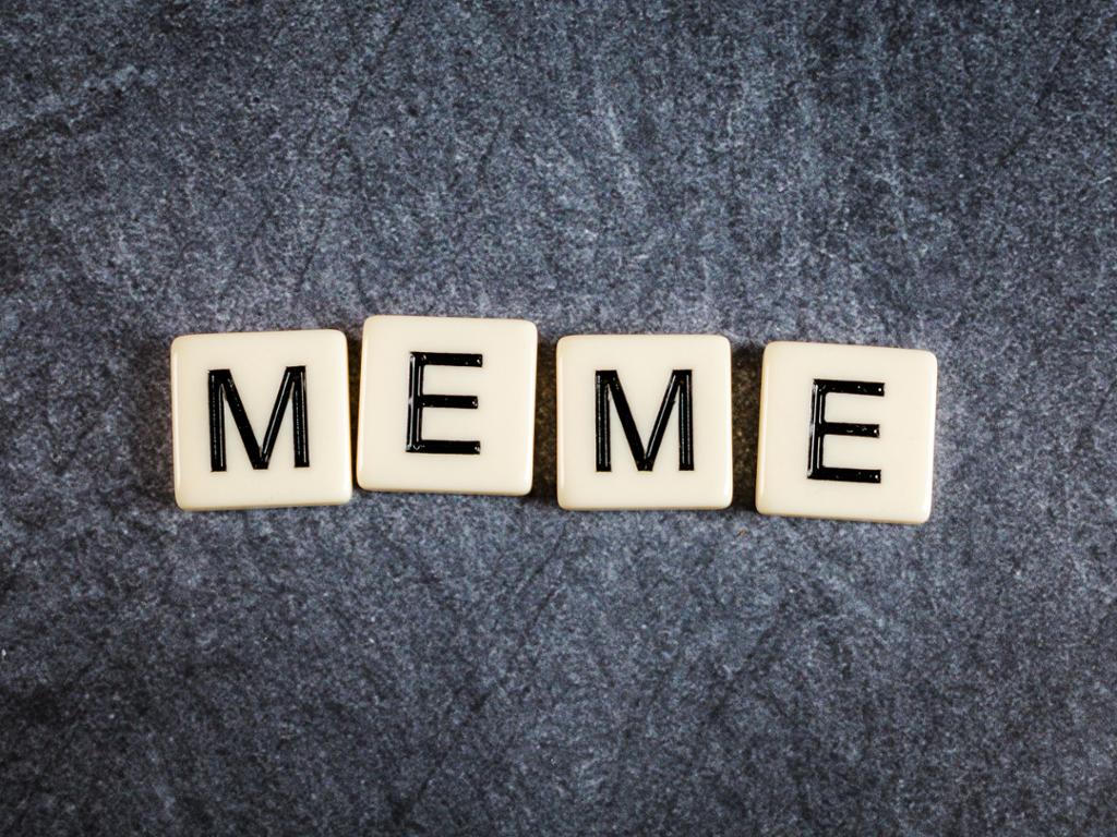 Scrabblebokstaver som former ordet "Meme". Foto.