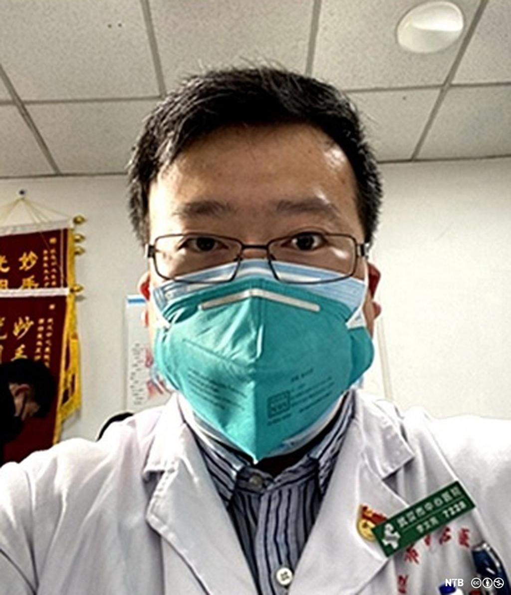 Den kinesiske legen Li Wenliang i arbeidstøy og med munnbind. Foto.