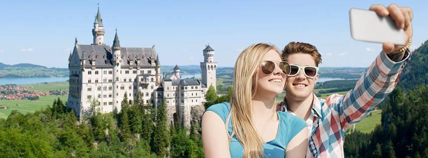 To ungdommar tek selfie foran eit slott. Foto.