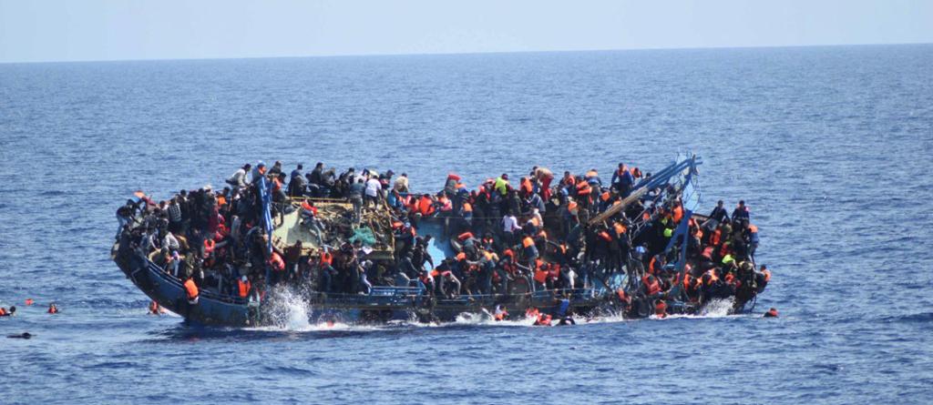 En overfylt flyktningebåt kantrer i Middelhavet