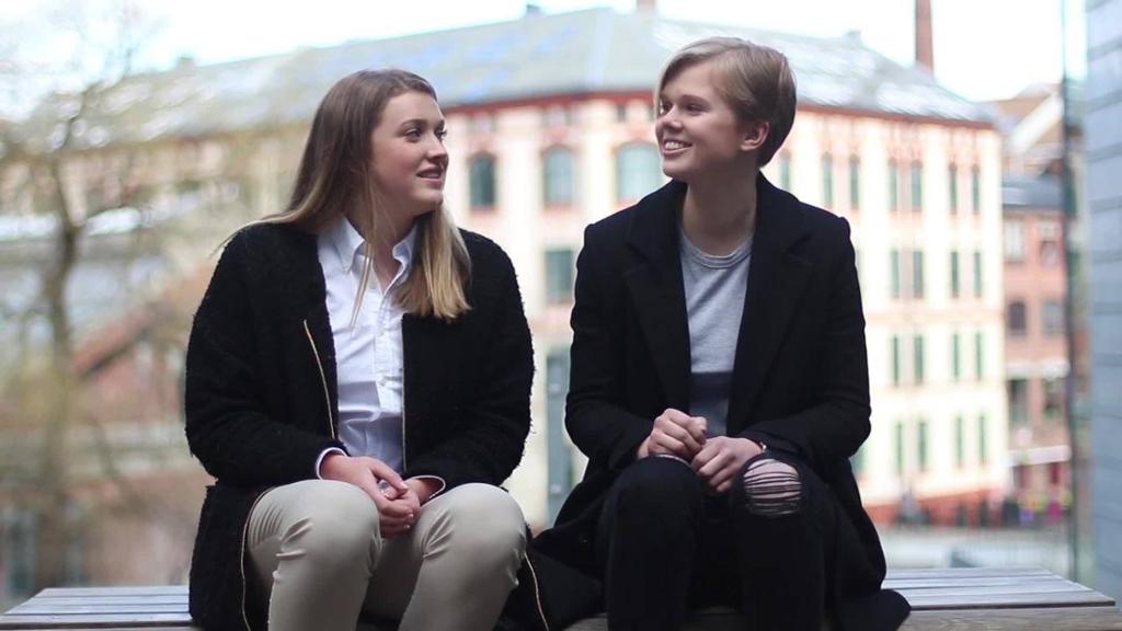 De to norske utvekslingselevene Julie Hausland Lundin og Emilie Byermoen, sittende på en benk i nærheten av Akerselva i Oslo. Foto.
