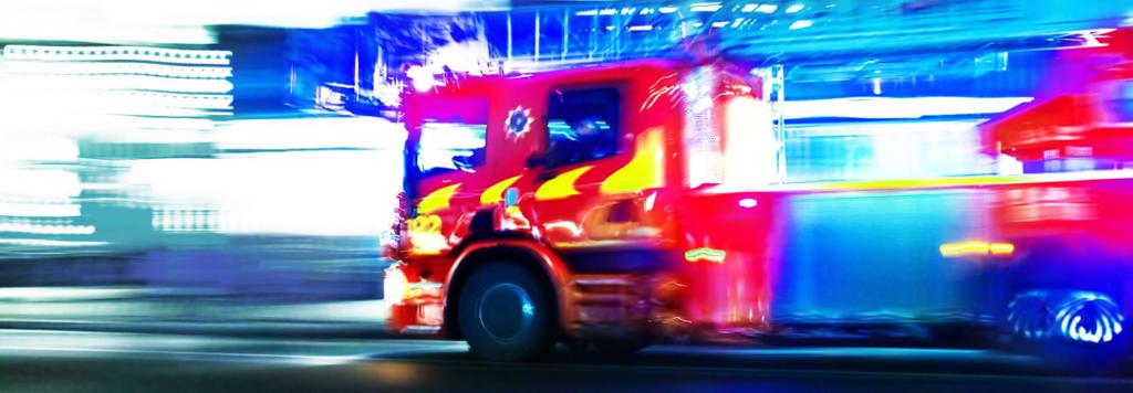 Ein brannbil køyrer med blålys. Foto.