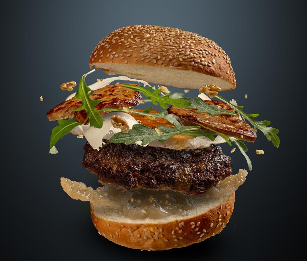 A hamburger in free fall, showing all its ingredients and the different layers. Photo. 