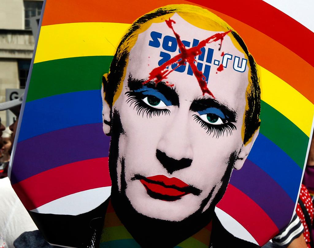 Bilde fra demonstrasjon mot OL i Sotsji. Popkunst-inspirert banner som viser en sminket Vladimir Putin med et regnbueflagg i bakgrunnen. Illustrasjon.