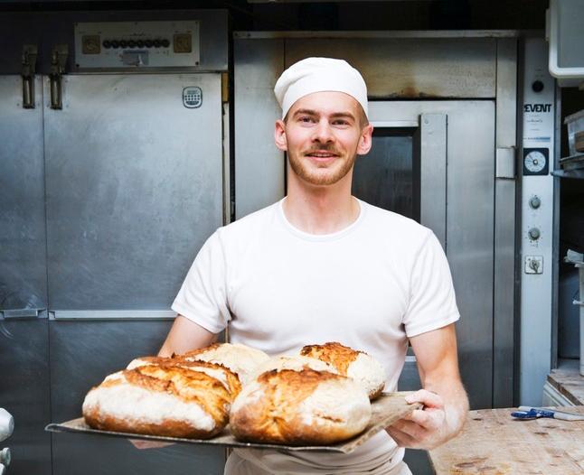 Baker med brød. Foto.