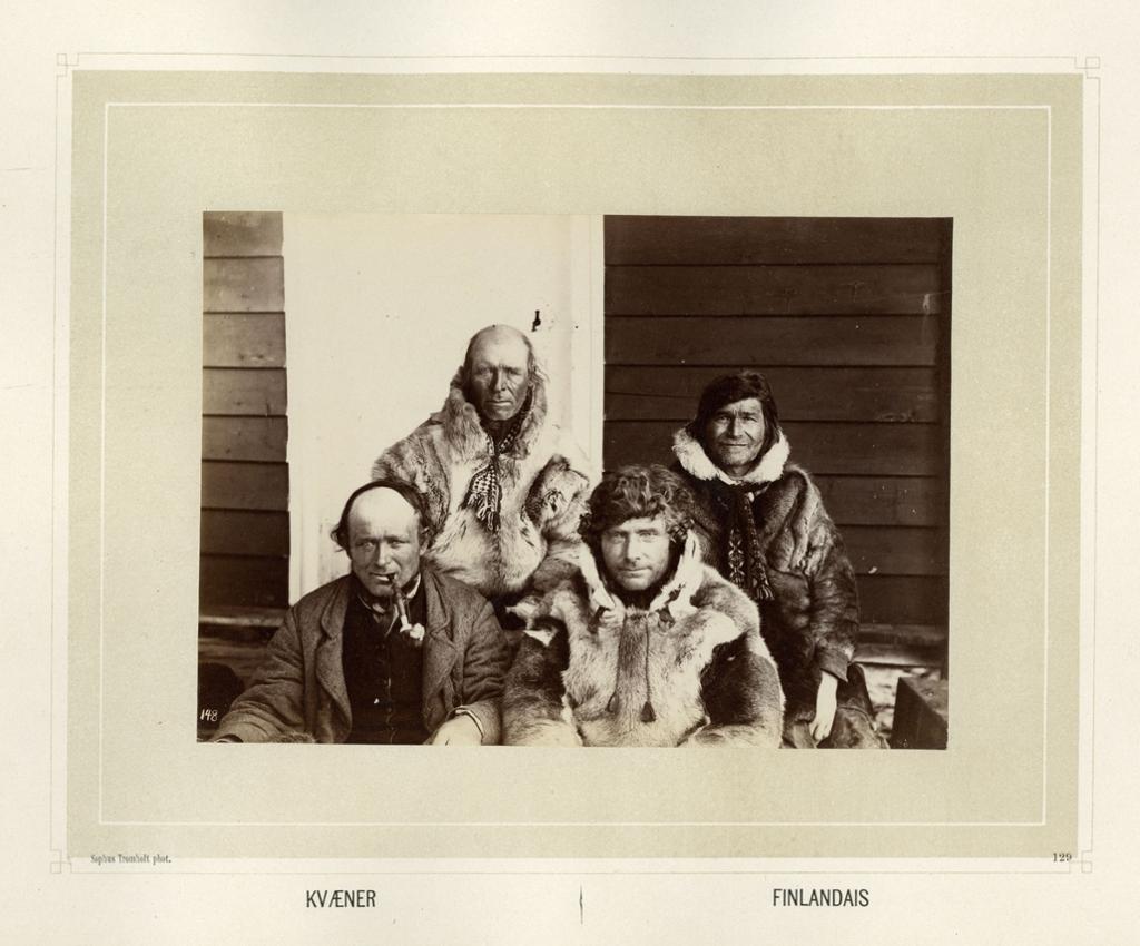 Fire menn sitter på ei trapp. Tre av dem er kledd i pesk og en i jakke. Det står Kvæner og Finlandais nederst på bildet. Svart-hvitt foto.