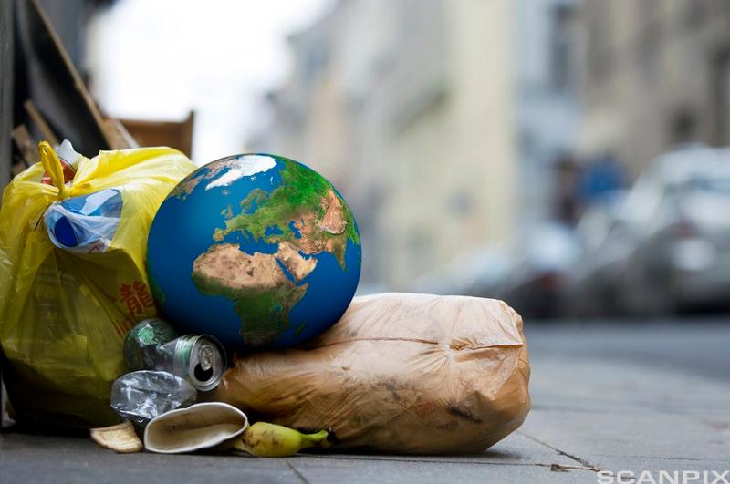 En globus ligger oppå søppel på en gate. Illustrasjon.