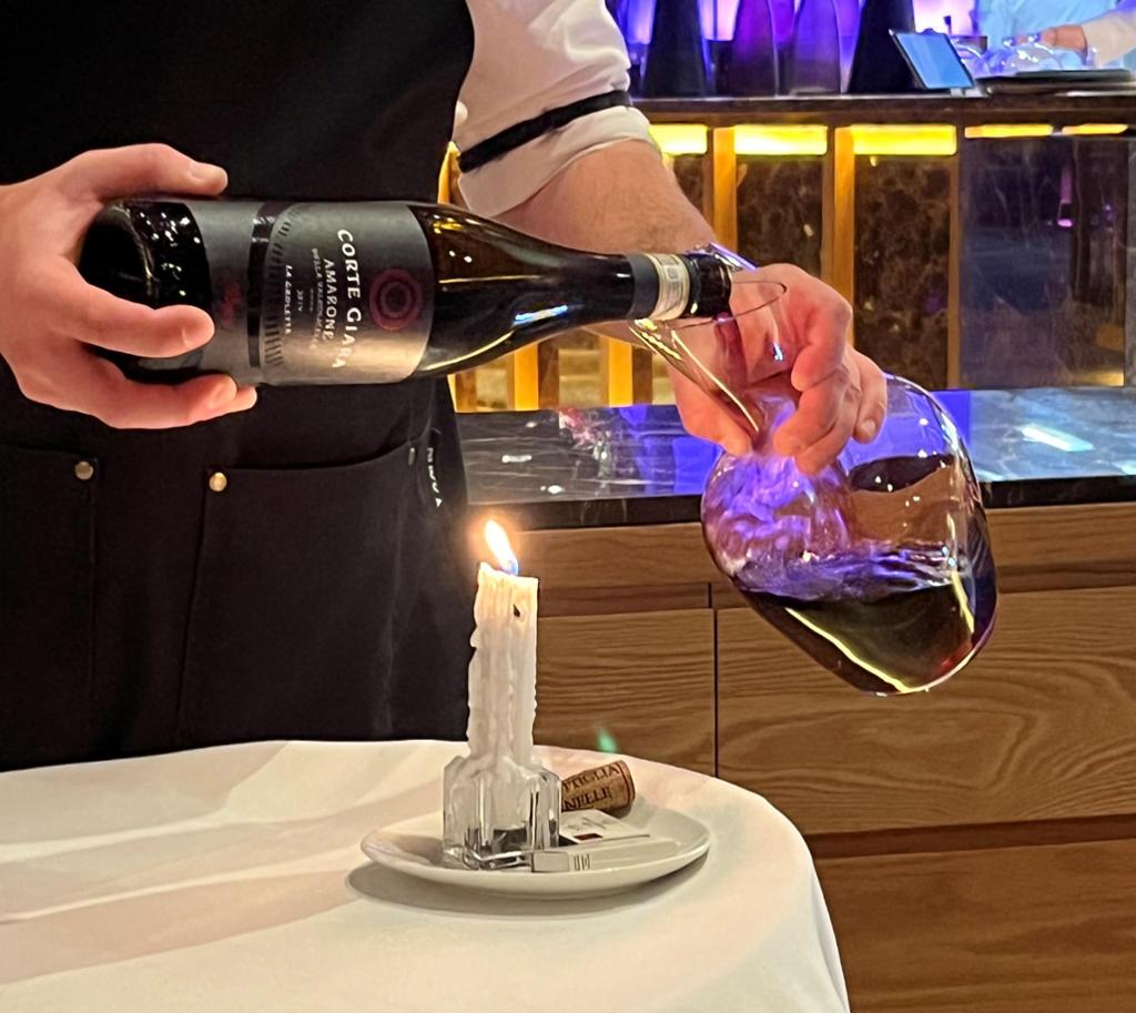 En servitør dekanterer en flaske vin. Foto.